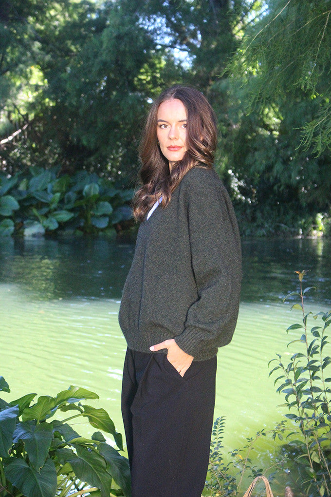 Woman wearing the Lothlorian - Merino & Possum Cavern V Neck Jumper (9789) in the colour Moss.