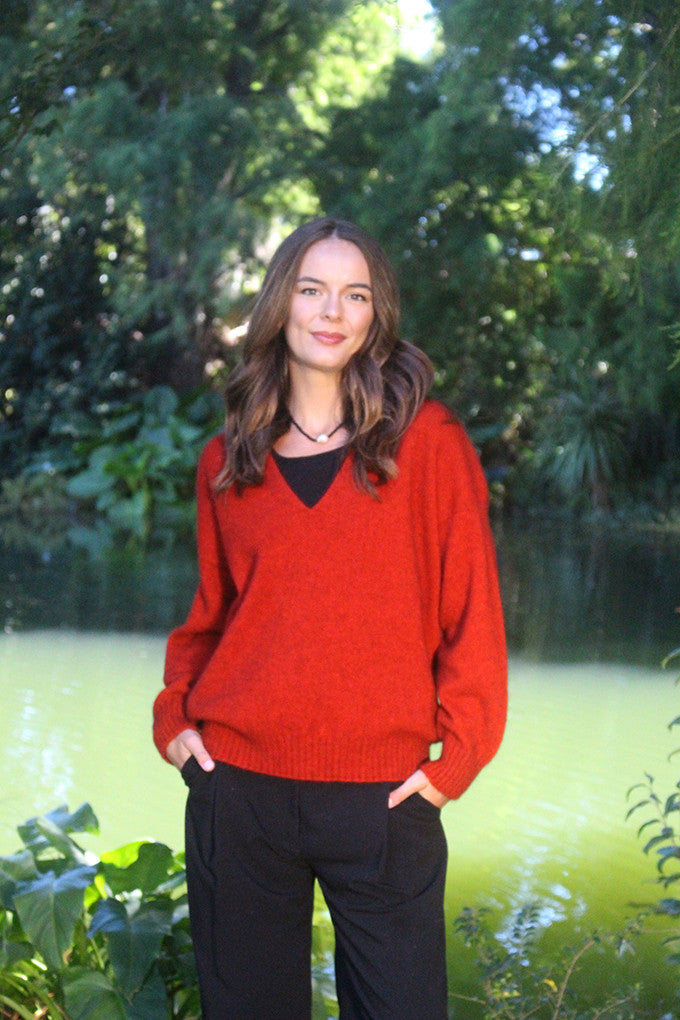 Woman wearing the Lothlorian - Merino & Possum Cavern V Neck Jumper (9789) in the colour Pumpkin.