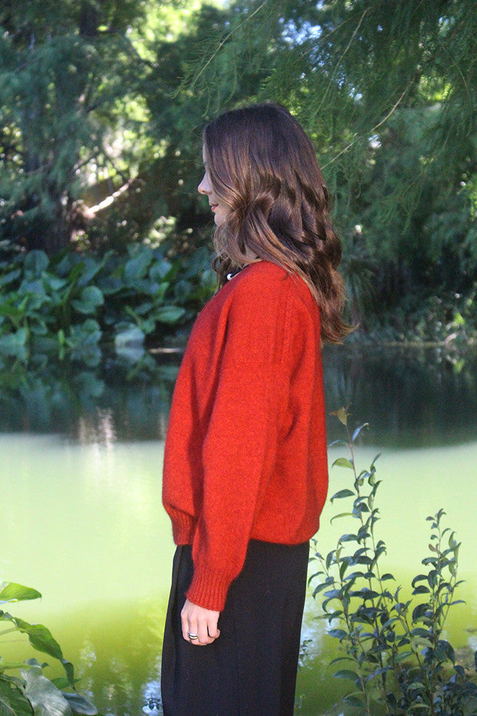 Woman wearing the Lothlorian - Merino & Possum Cavern V Neck Jumper (9789) in the colour Pumpkin.