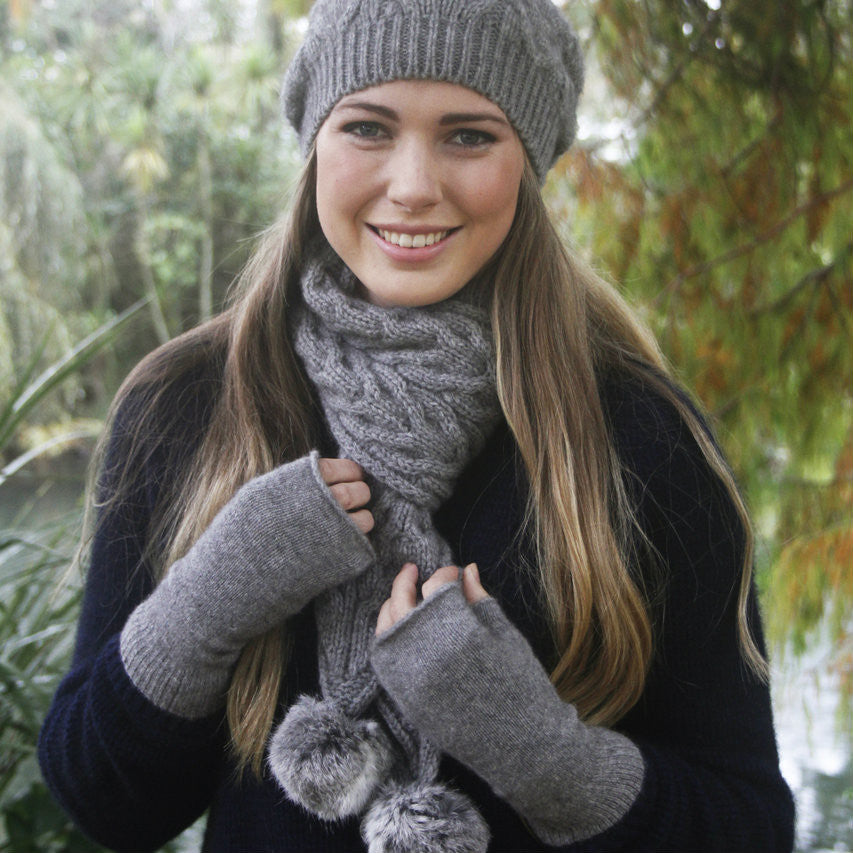 Silver - Woman holding scarf. Wearing gloves.
