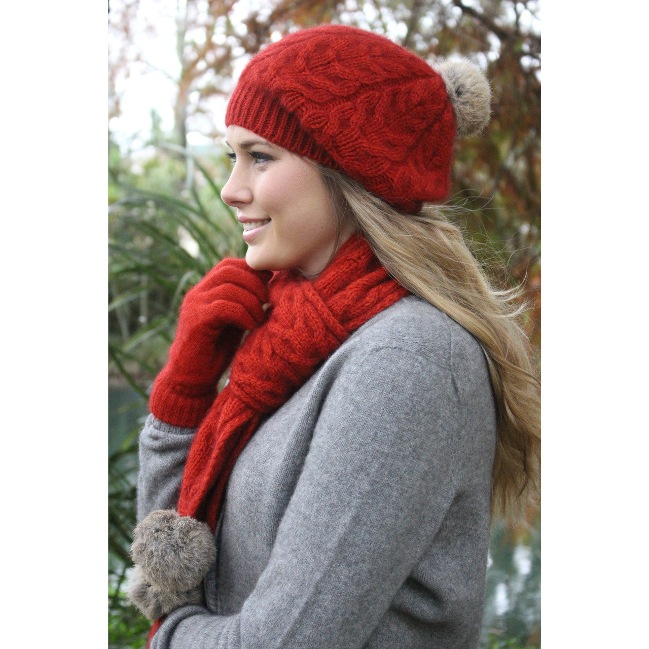 Blonde woman wearing red beanie, red scarf and red gloves. 