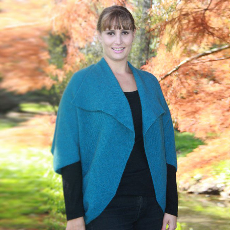 Woman wearing Takahe cape in colour Teal