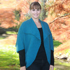 Woman wearing Takahe cape in colour Teal