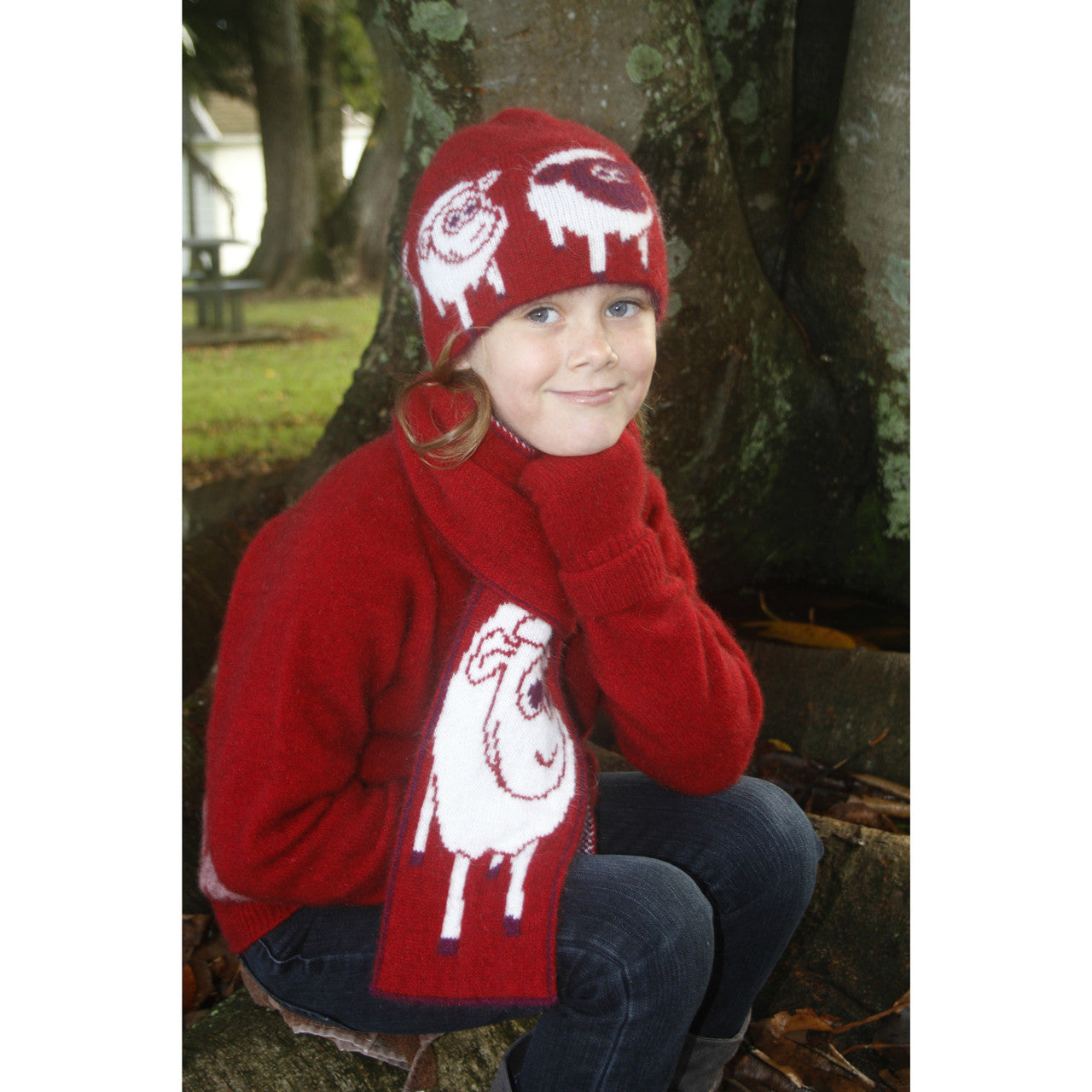 Girl sitting to the side wearing Beanie in colour red.