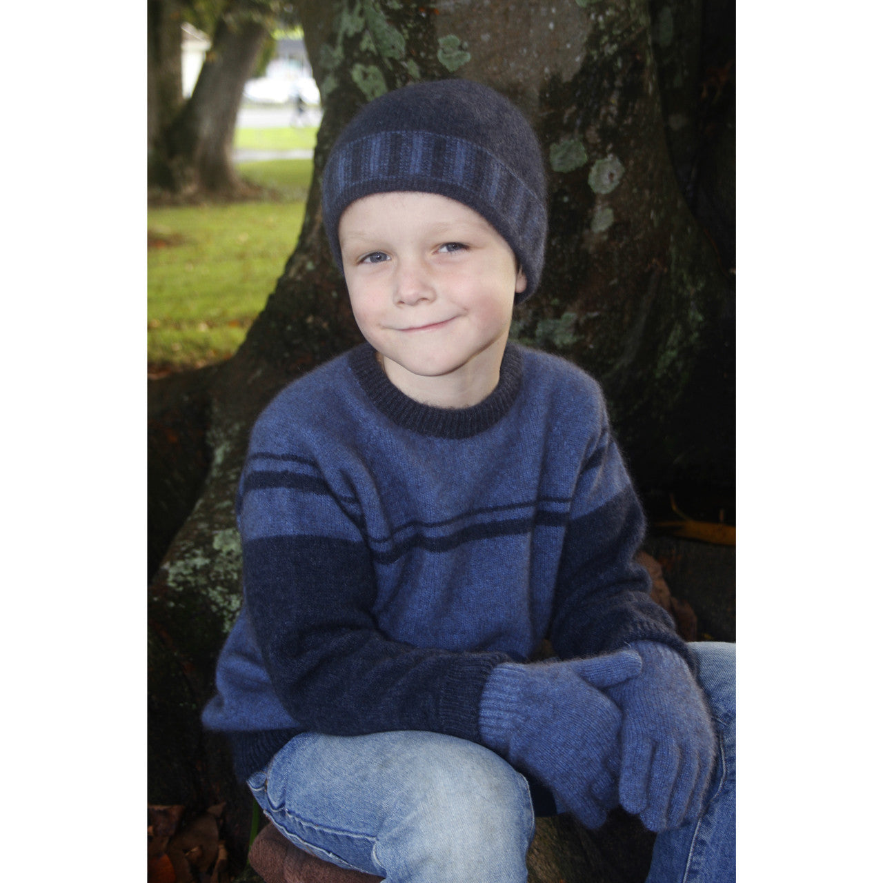 Boy sitting wearing Denim colour jumper.