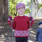 Girl by swing wearing Jumper in colour red.