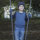 Boy holding swing wearing light blue colour vest.