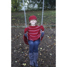 Girl sitting on swing wearing red Gatsby hat.