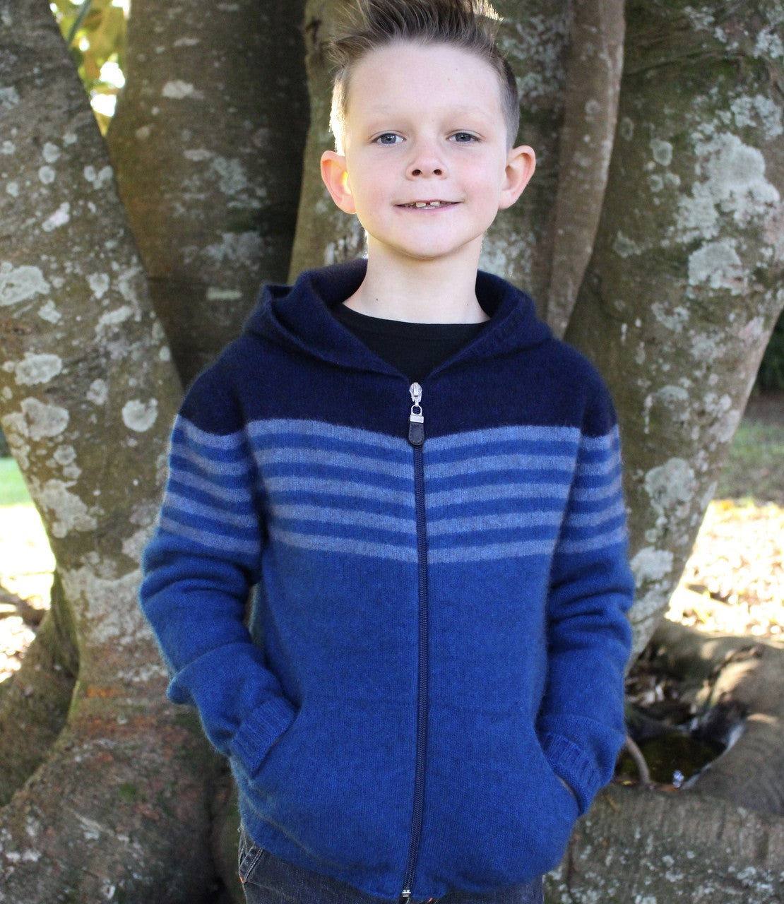 Boy standing wearing lagoon colour striped hoodie.