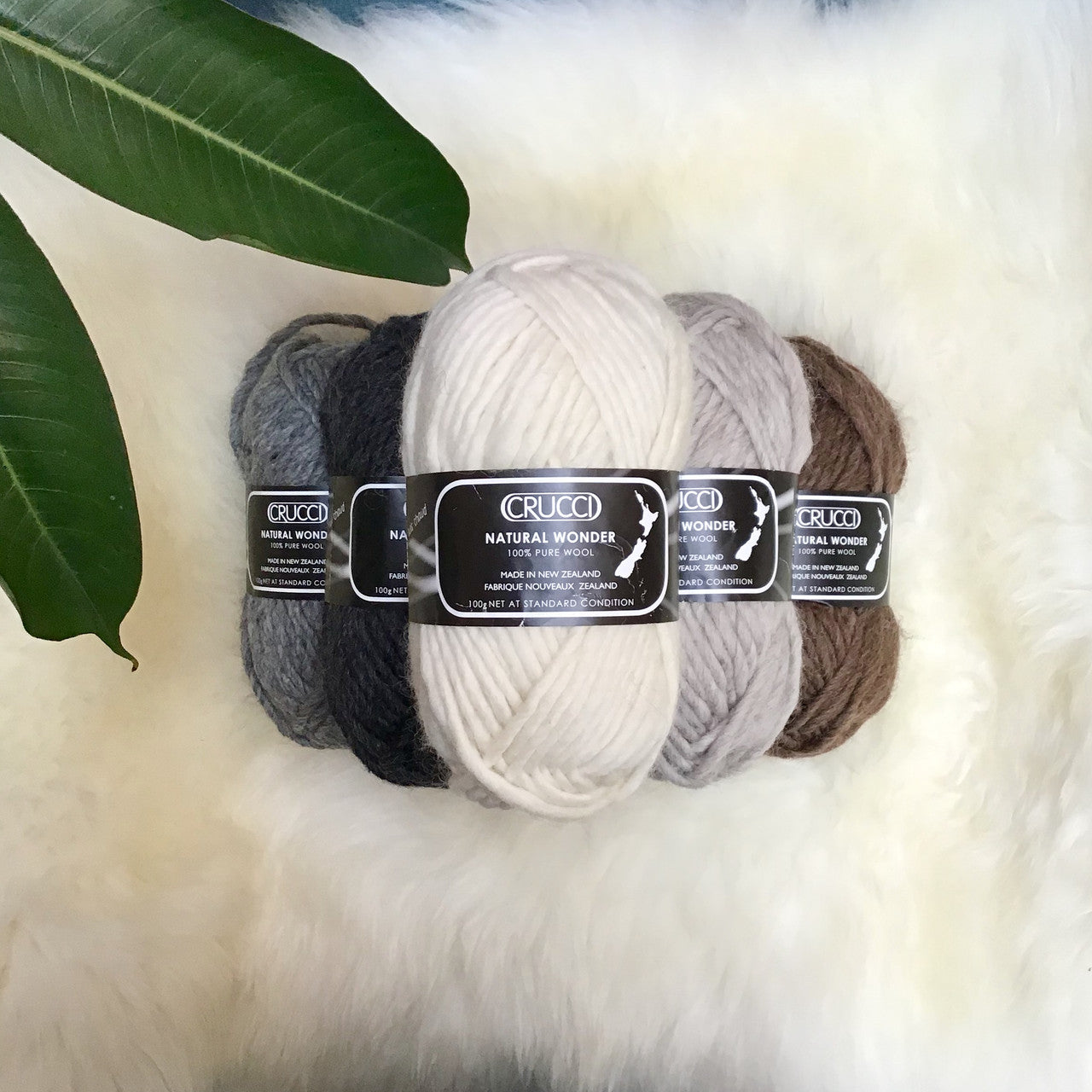 Stack of balls of yarn in different colours from top view.