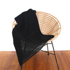 Black-coloured Knight Mohair Throw draped over chair.