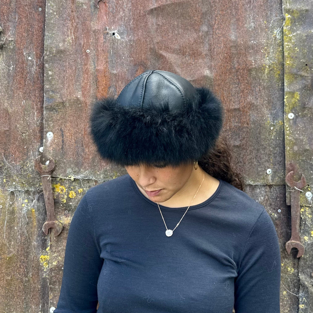 Woman standing wearing a Black coloured Four Peaks Classic Panelled Lambskin & Possum Fur Hat.
