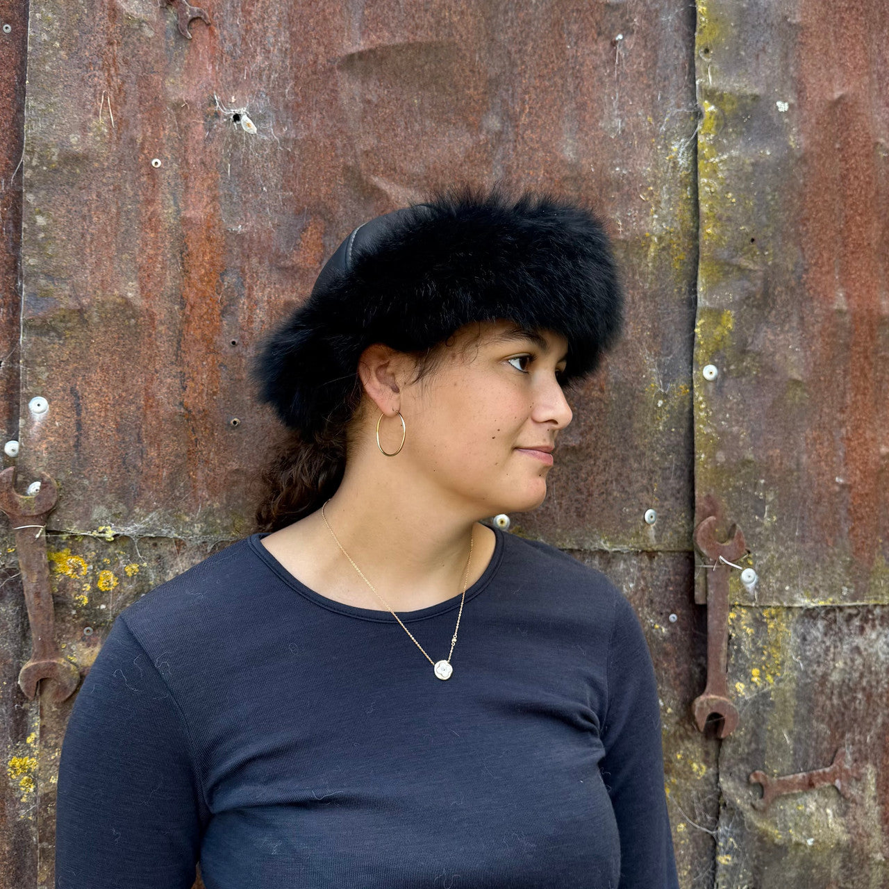Woman standing wearing a Black coloured Four Peaks Classic Panelled Lambskin & Possum Fur Hat.