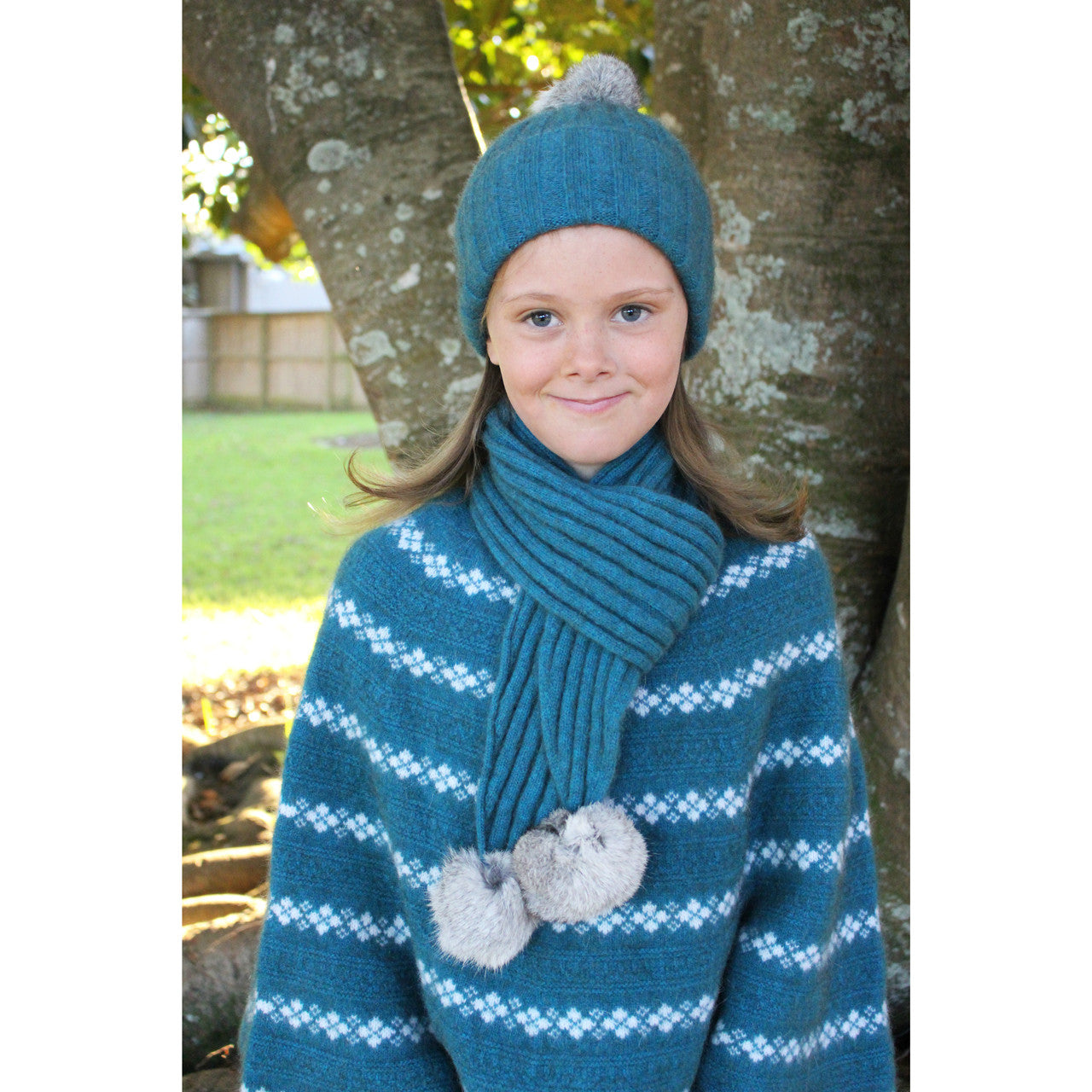 Girl wearing Poncho in colour teal.