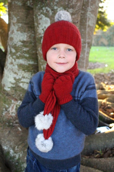 Child wearing matching beanie, scarf and gloves. Colour Red