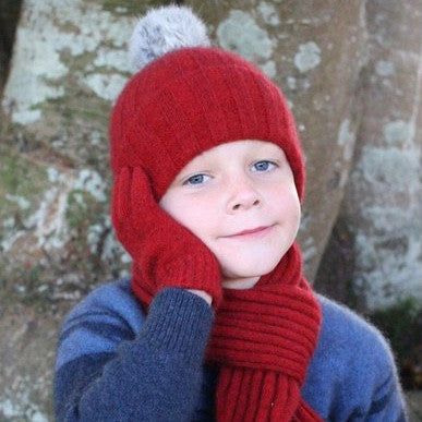 Child wearing beanie, scarf and gloves. Colour Red
