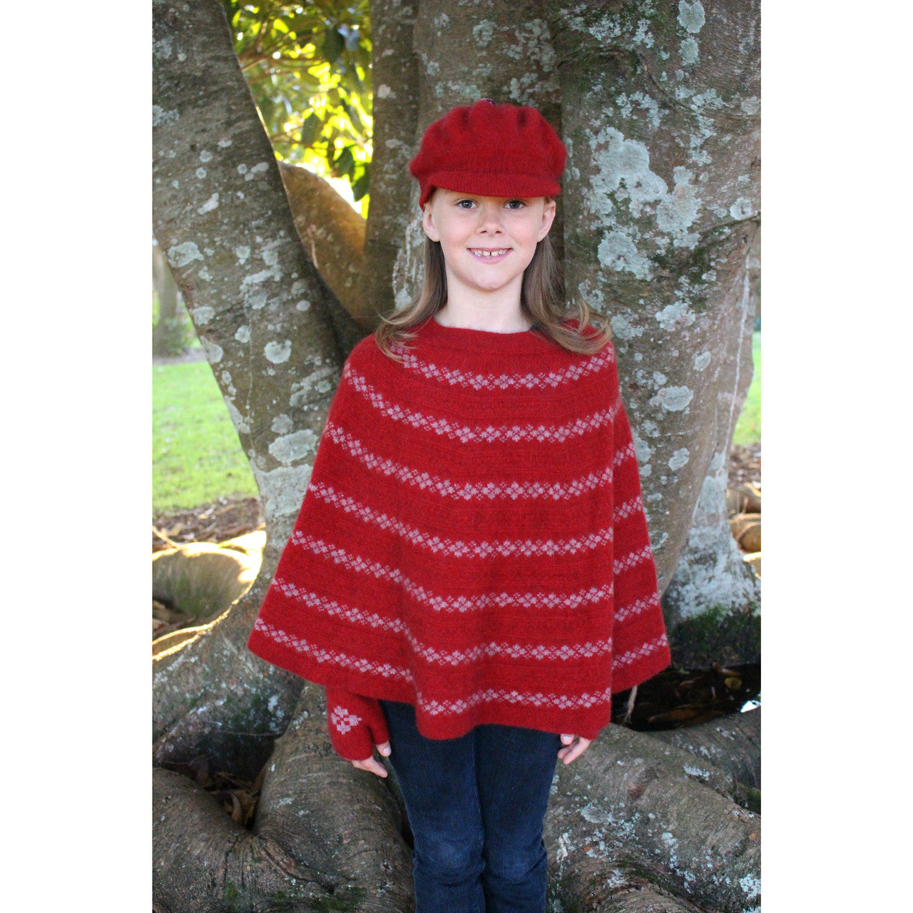 Girl standing wearing Poncho in colour red.