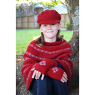 Girl sitting wearing Poncho in colour red.