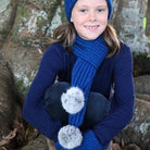 Girl wearing lagoon colour scarf, beanie and glove set.