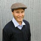 Man wearing Bingley Check Lambswool Tweed Cheesecutter hat in olive colour.