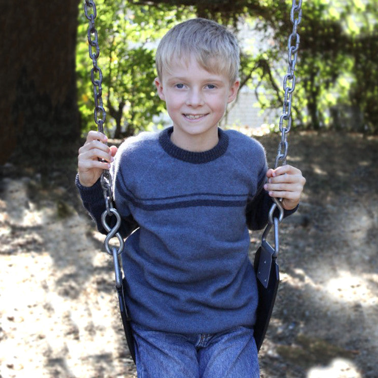 Boy on swing wearing Denim colour jumper.