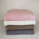 Stack of different coloured baby blankets.