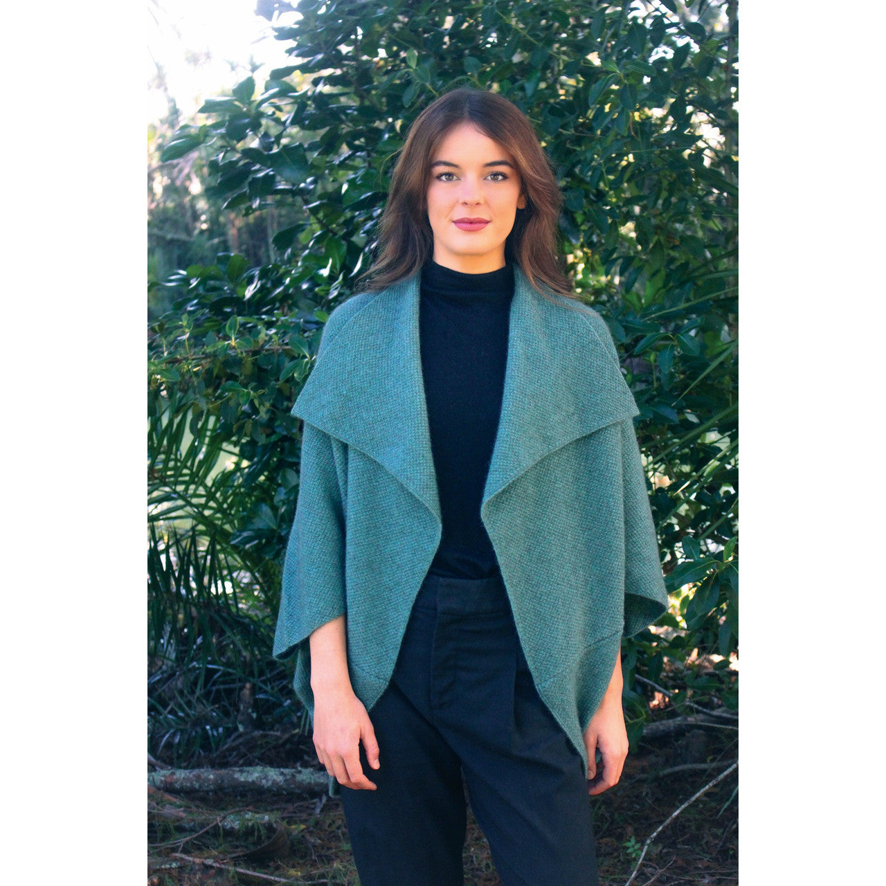Woman wearing Takahe cape in colour Sage