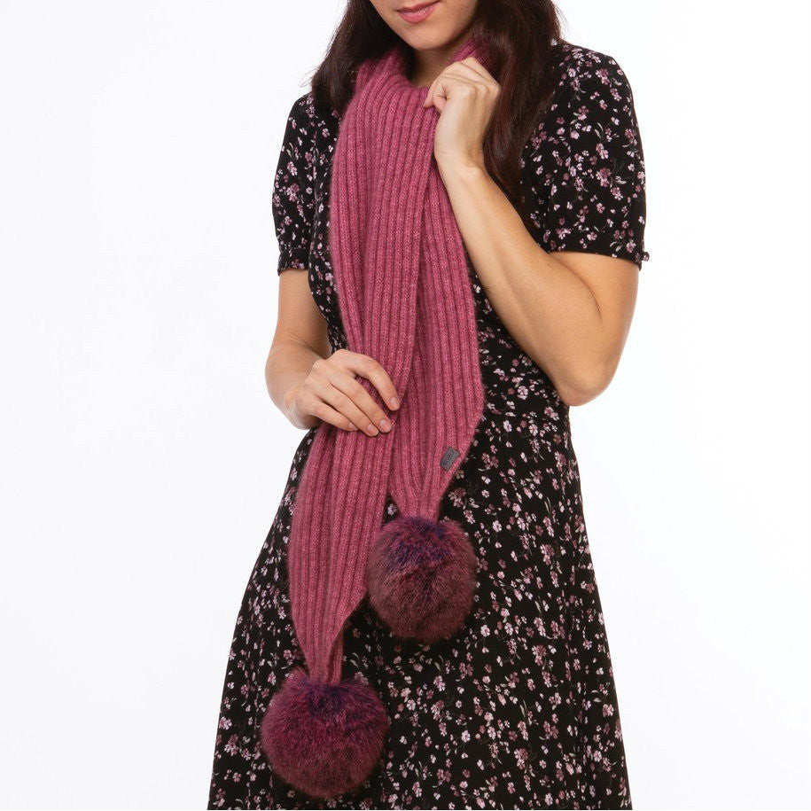 Woman wearing a rose and wildberry coloured Koru merino and possum fur Pom Pom Scarf.