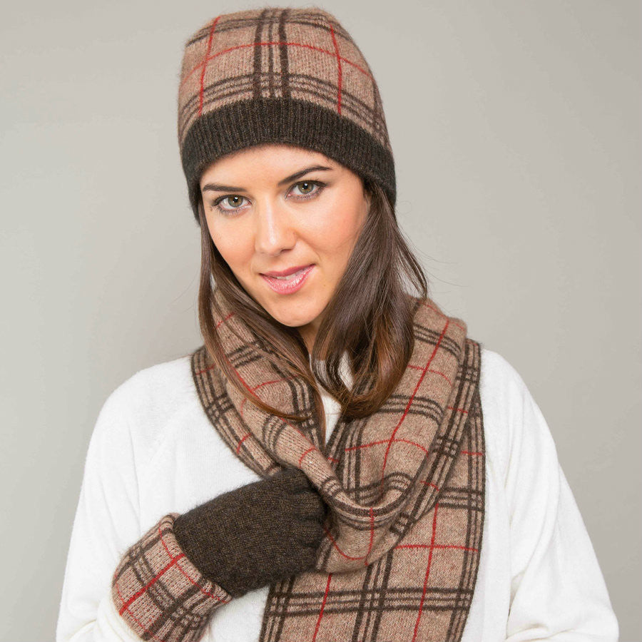 A woman wearing a mocha, espresso, and rata-coloured Koru merino and possum Tartan Scarf.