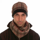 A man wearing a mocha, espresso, and rata-coloured Koru merino and possum Tartan Scarf.