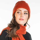 A woman wearing an sienna-coloured Koru Merino and Possum Plain Beanie.