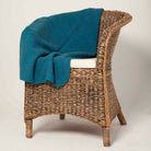 Pacific-coloured Koru Merino and Possum Diamond Throw draped over chair.