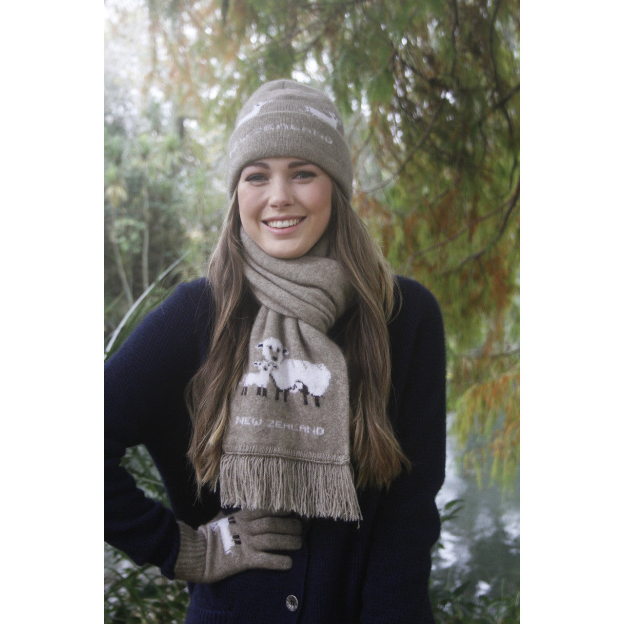 Woman standing outside wearing sheep detailed scarf, beanie and gloves