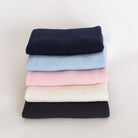 Stack of different coloured baby blankets.
