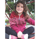 Girl sitting wearing fuchsia colour striped hoodie.