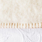 White wool blanket with darker stitching.