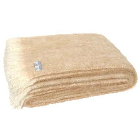 Folded Alpaca fleece throw in sand colour.