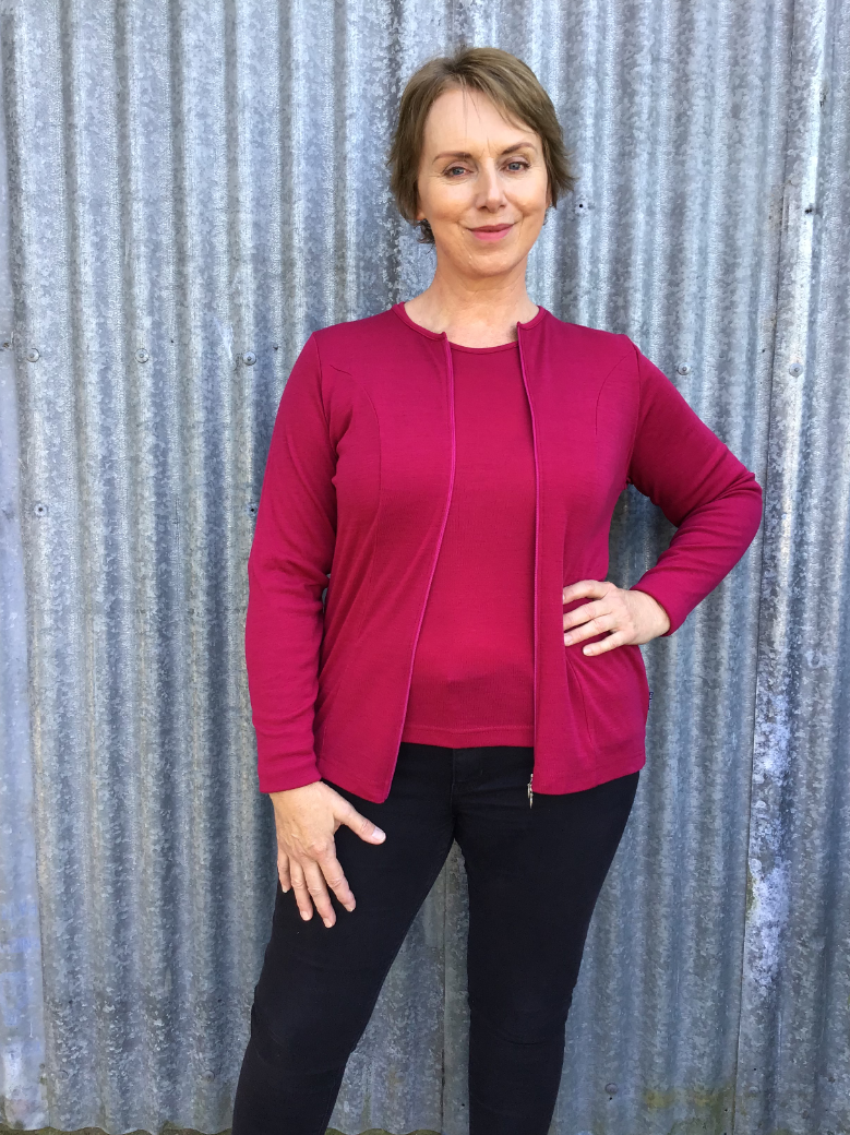 Woman with hand on hip wearing zipped Catherine Cardigan in Cerise
