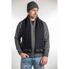 Man standing wearing a black Koru merino and possum NZ Supporters Silver Fern Scarf.